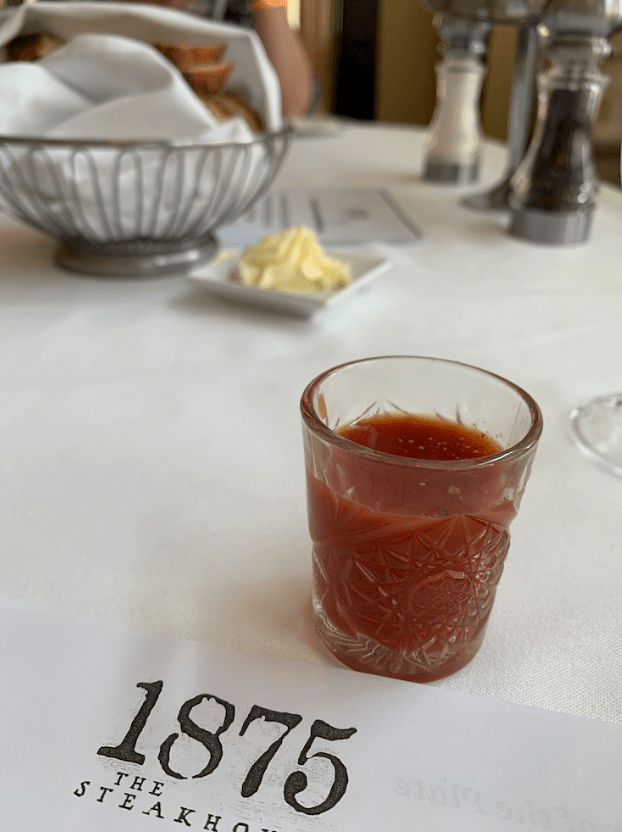 a glass of red liquid on a table