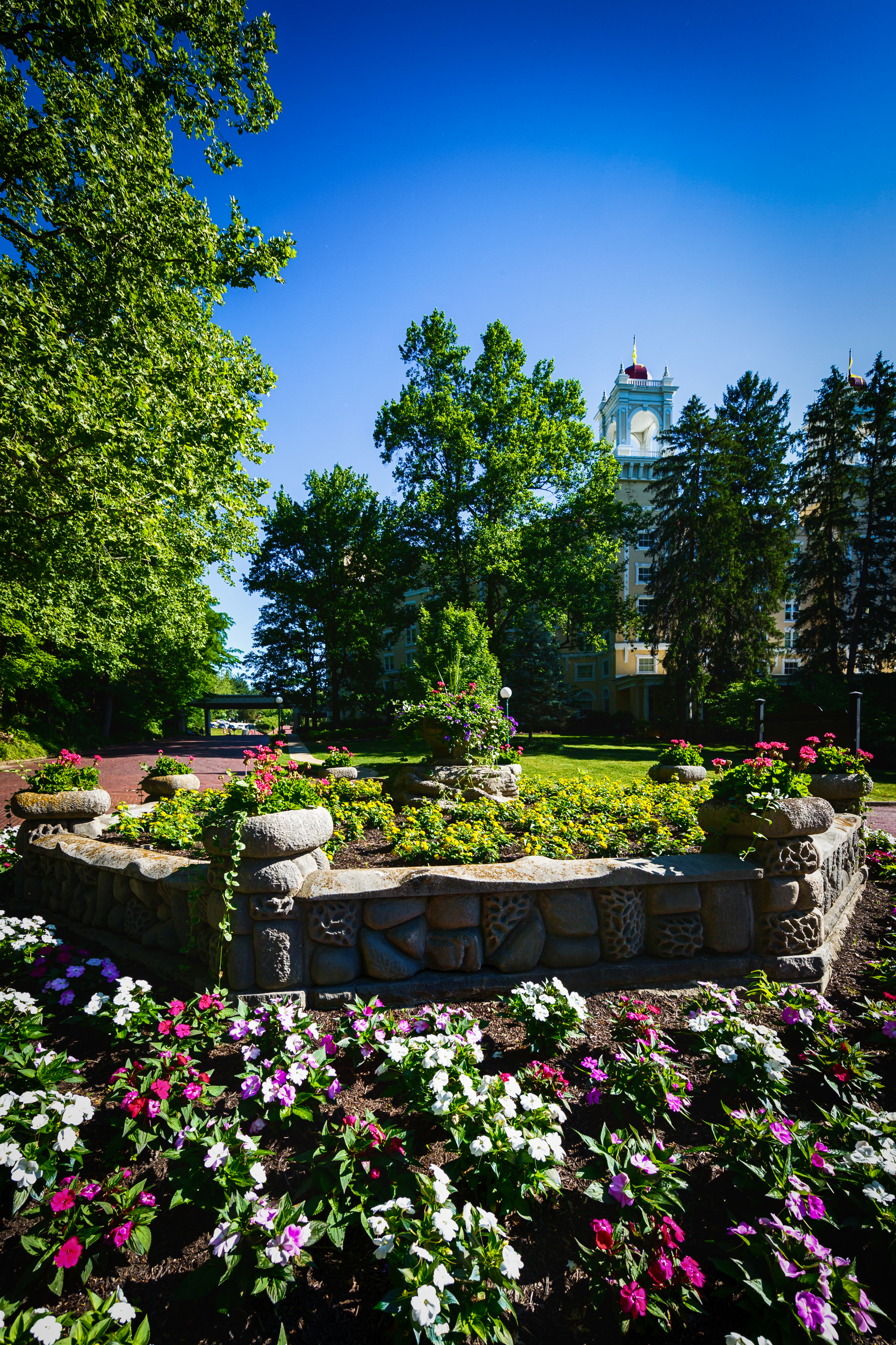 a stone garden with flowers and trees in the background