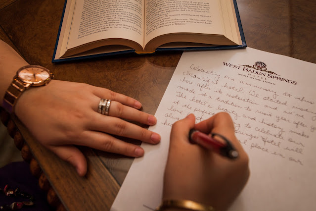 hands writing a letter