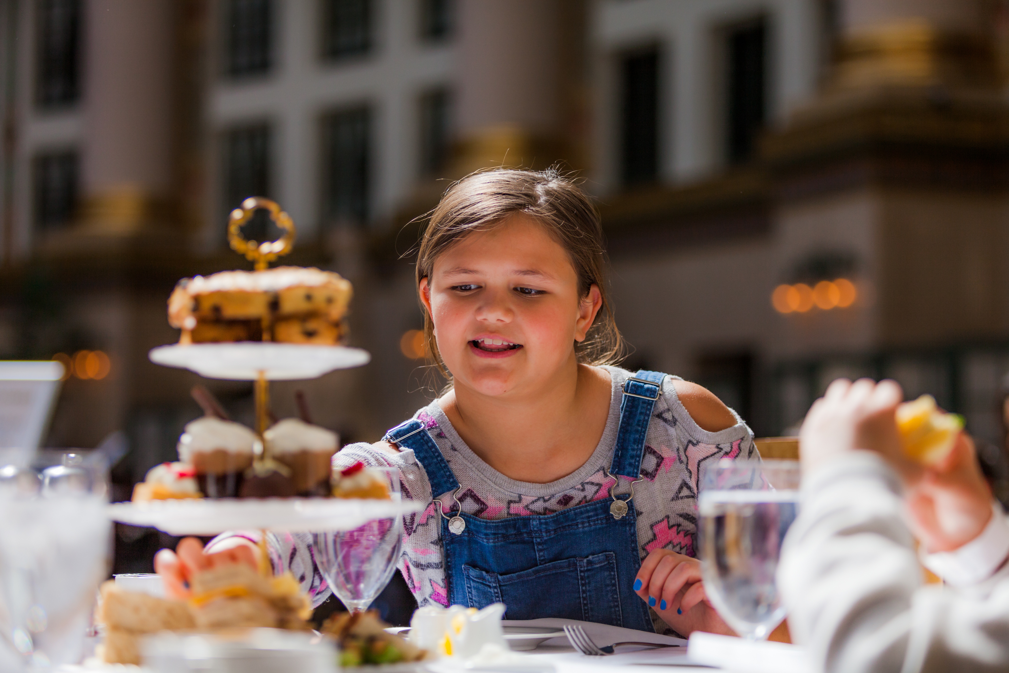 a girl looking at a tiered cake
