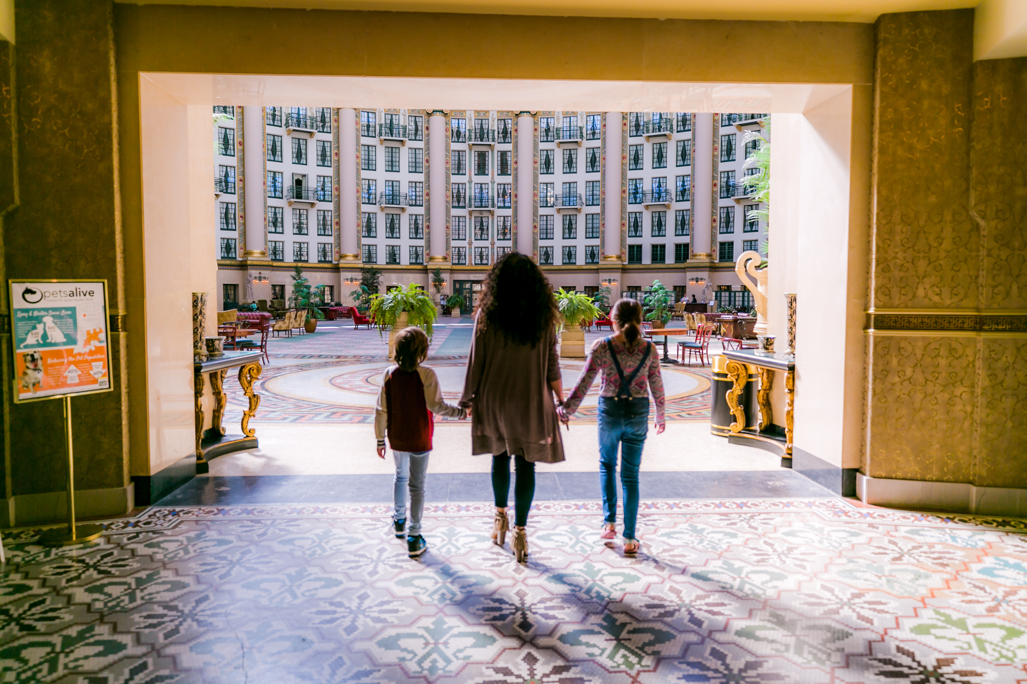 A woman and children walking into a large building