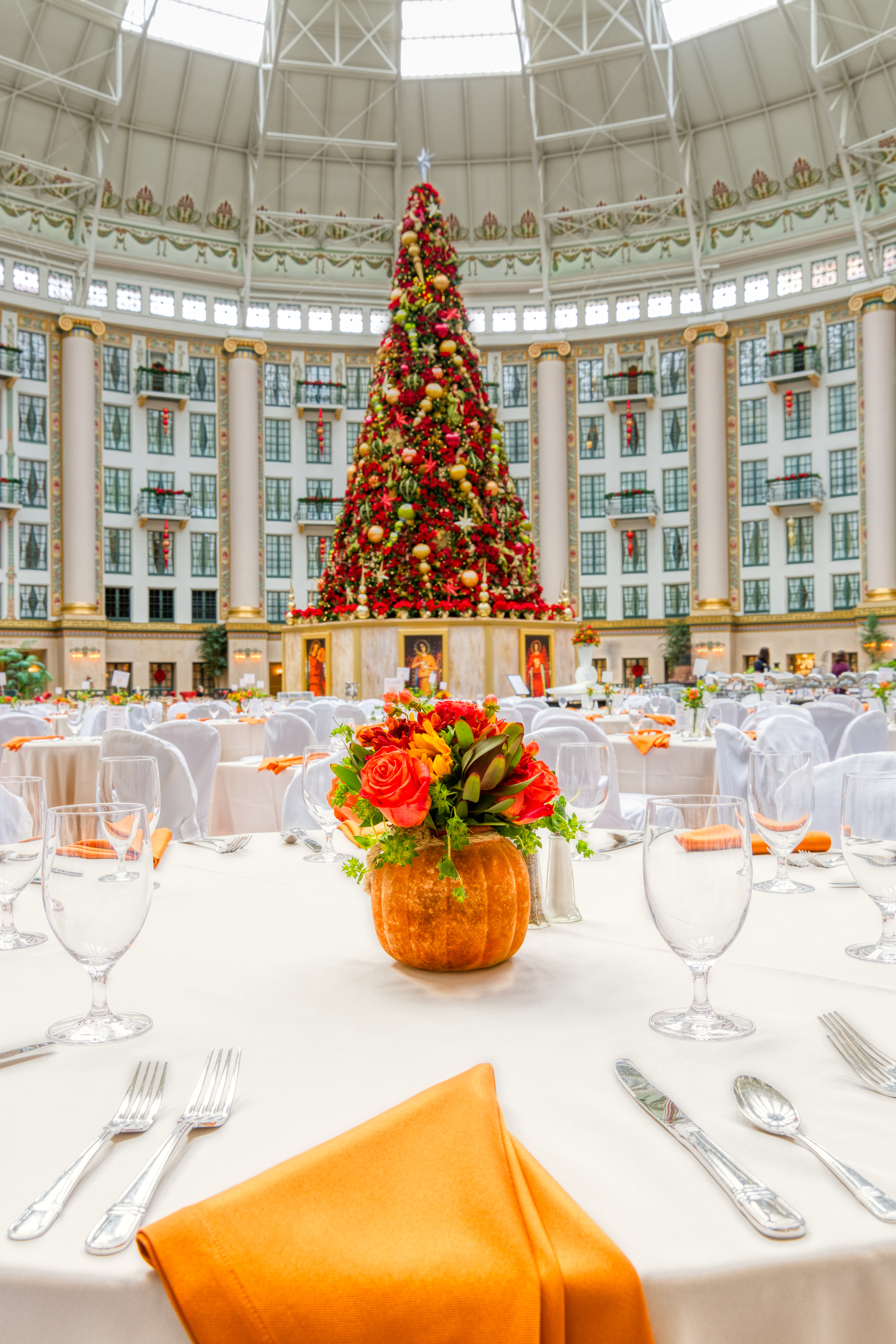 a decorated table in a large room with a christmas tree