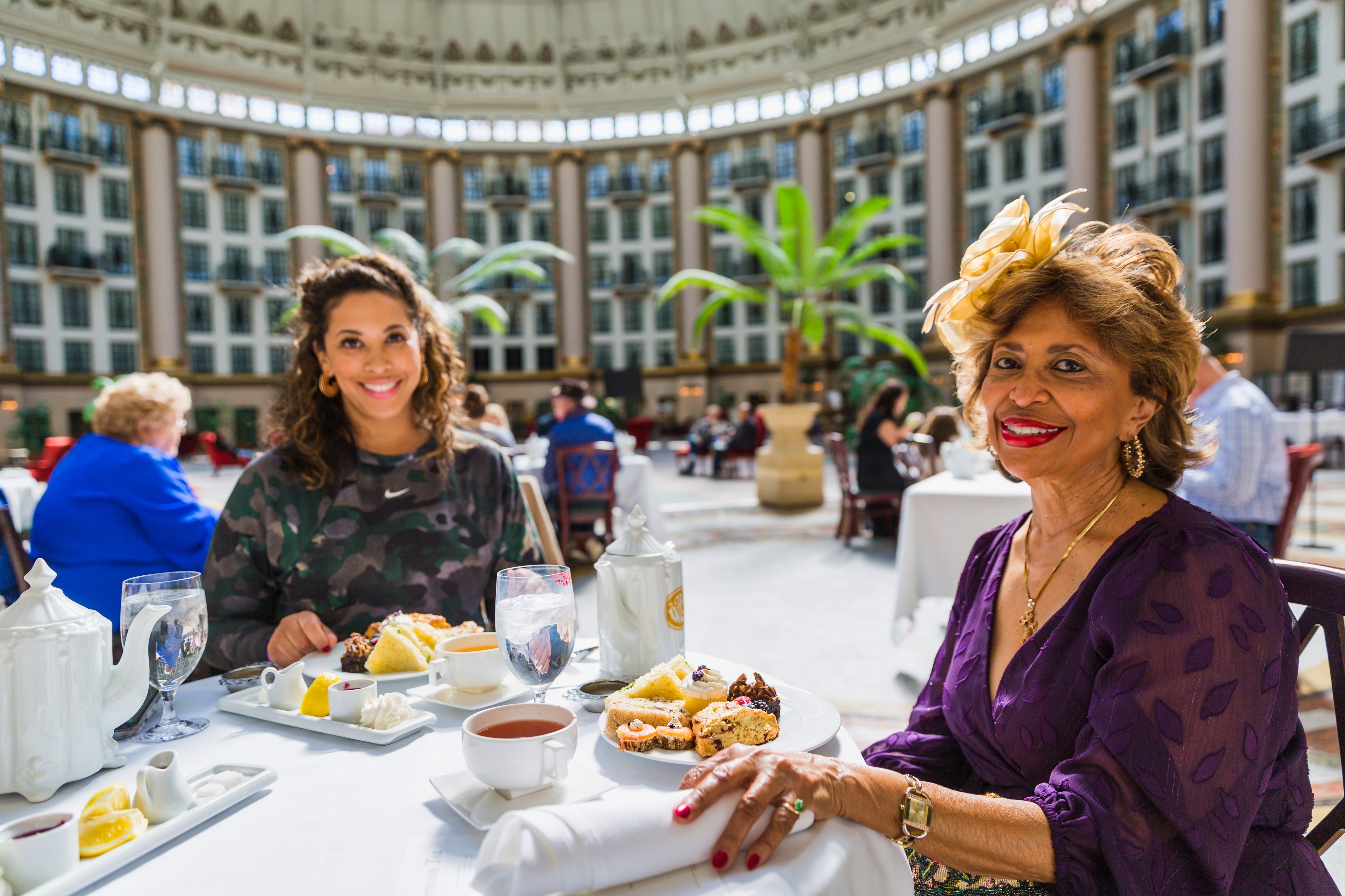 two women sitting at a table with food