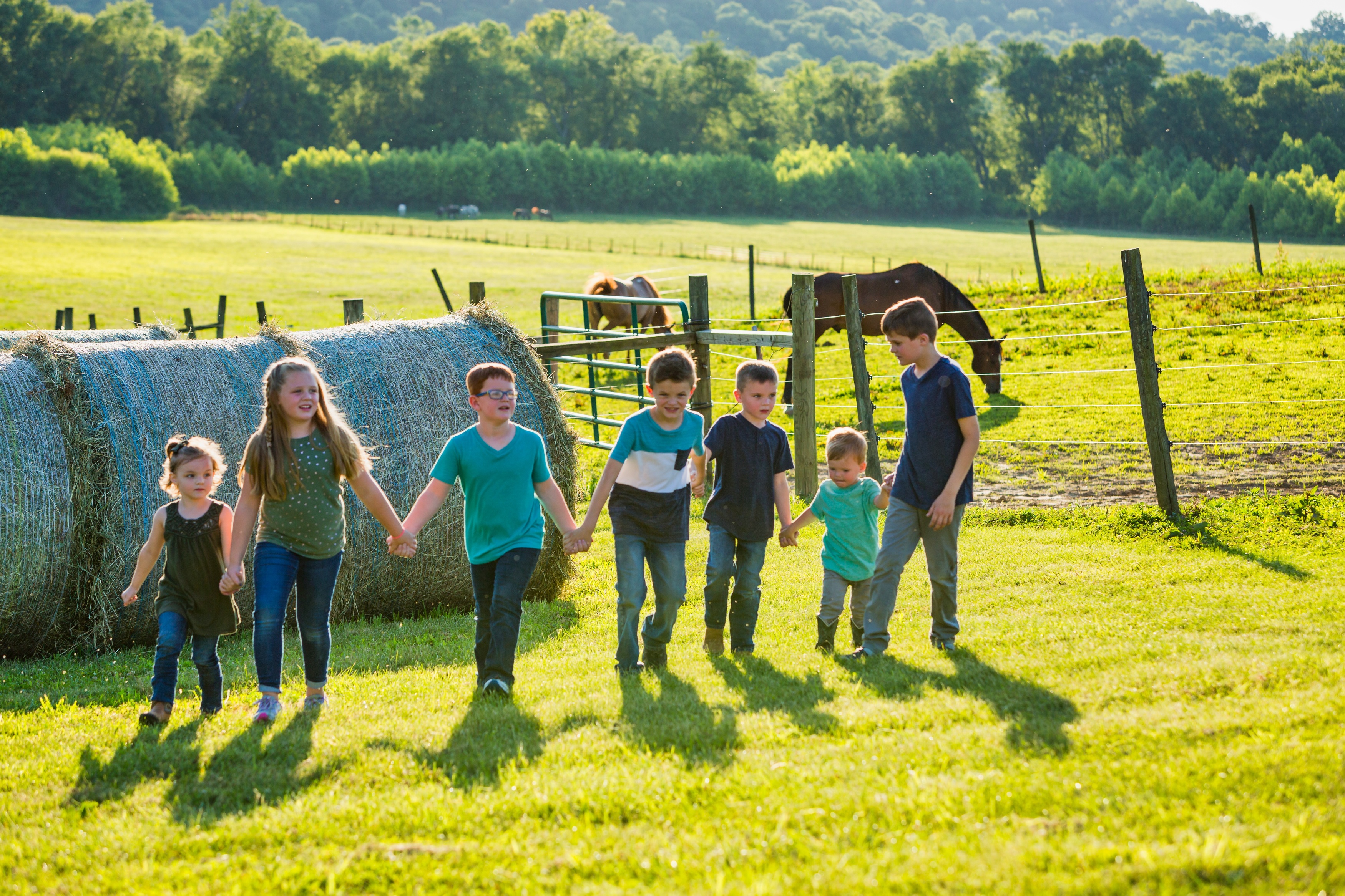 a group of children holding hands in a field