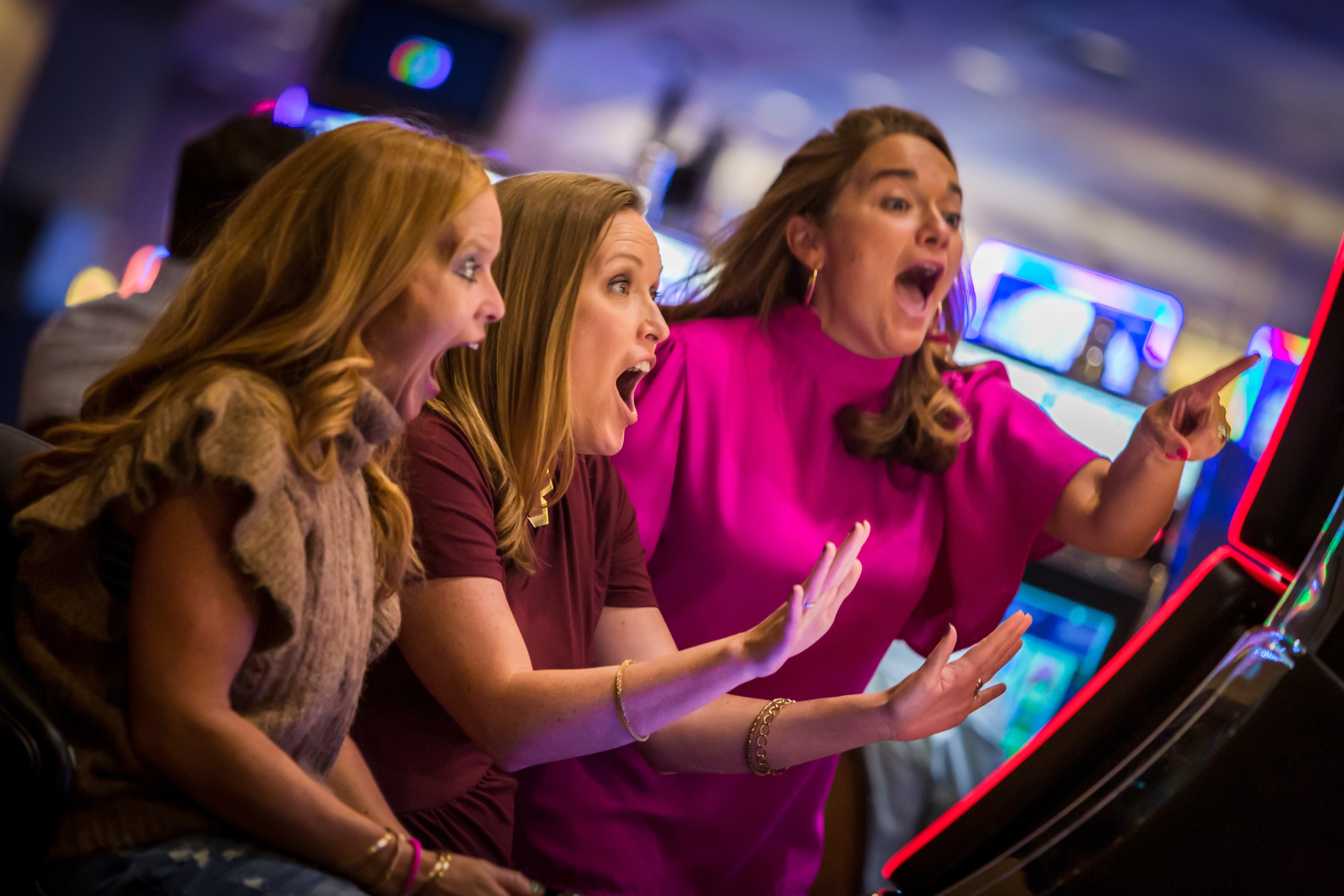 a group of women playing slot machines