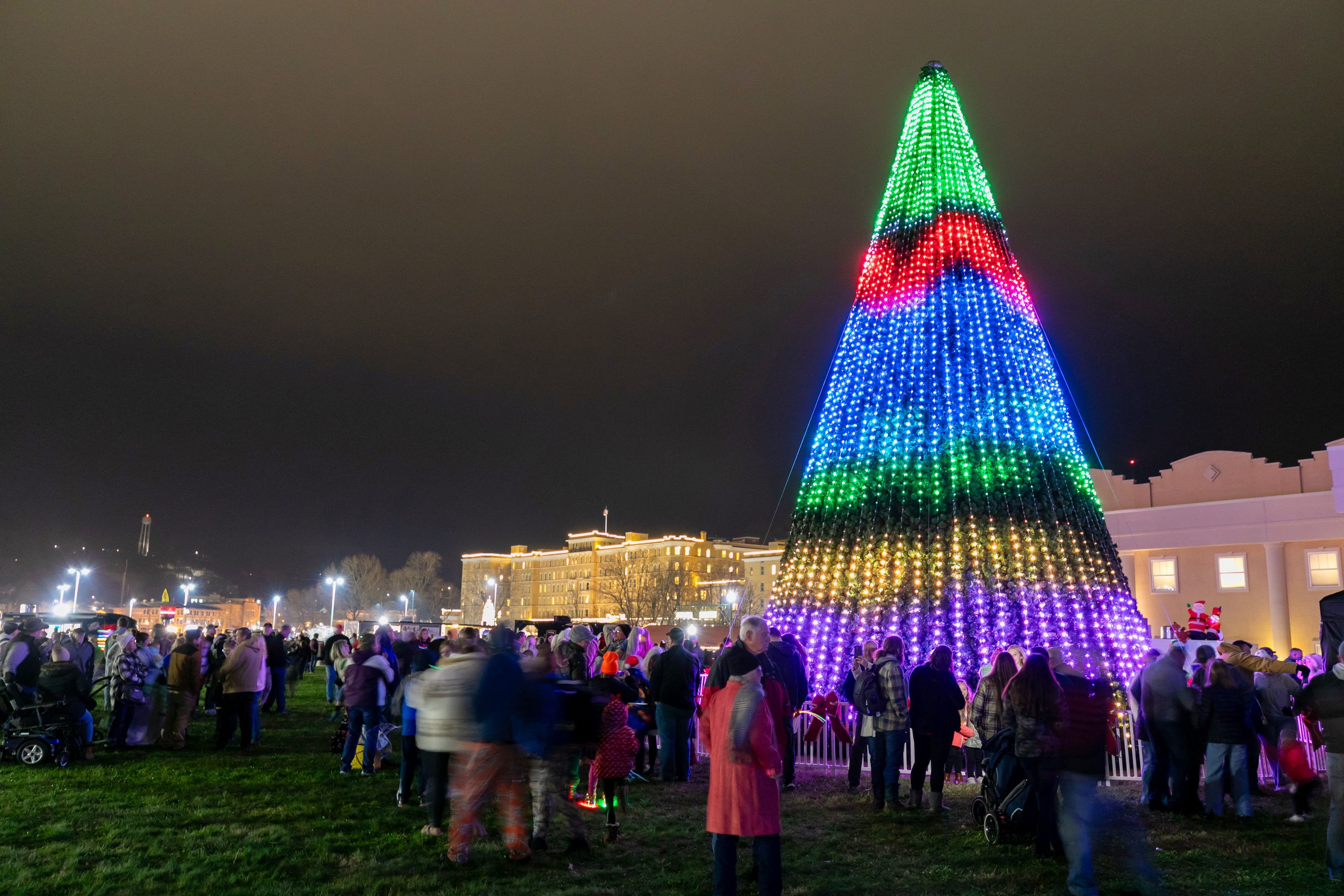 a group of people around a christmas tree