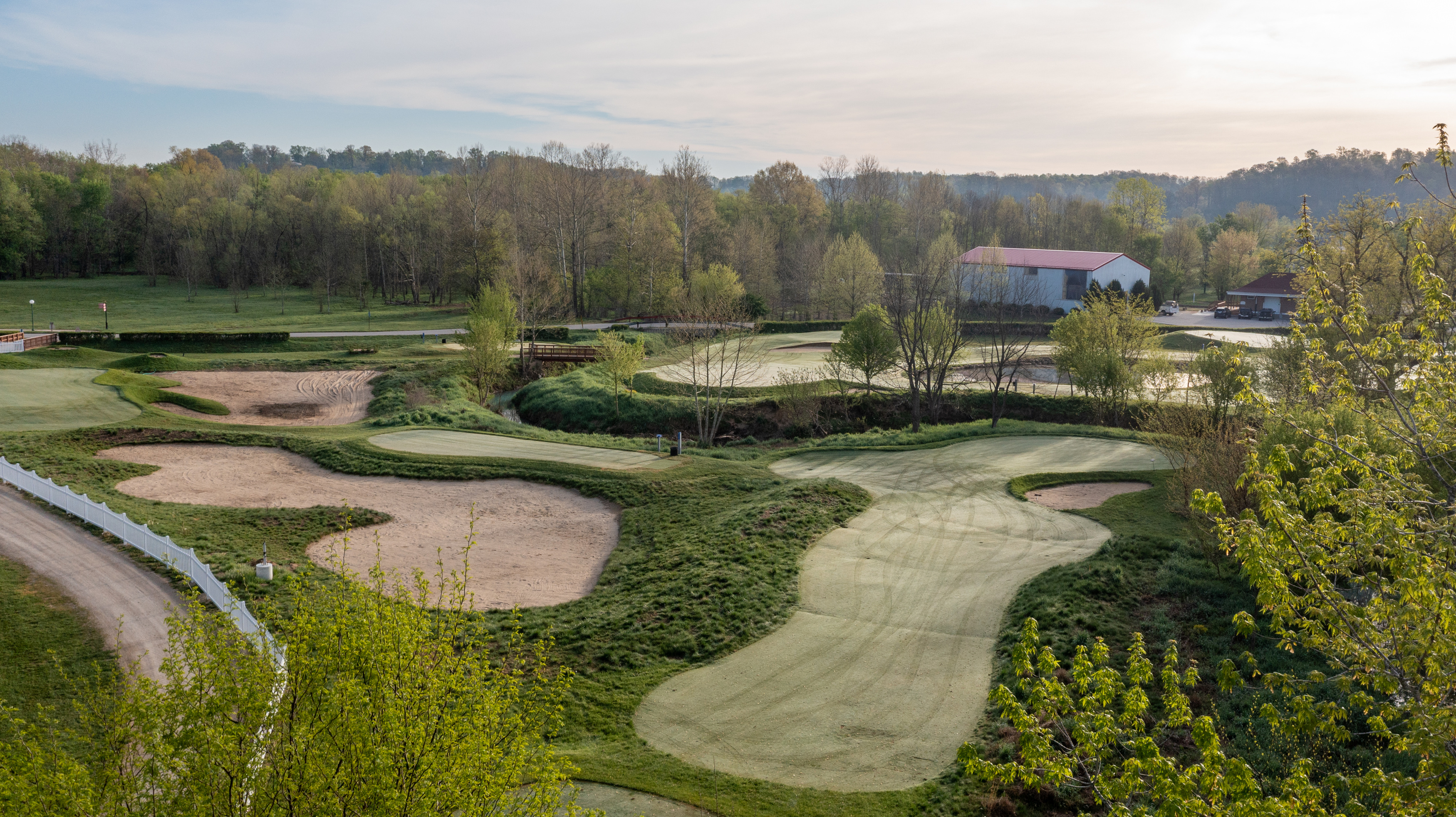 a golf course with sand bunkers and trees