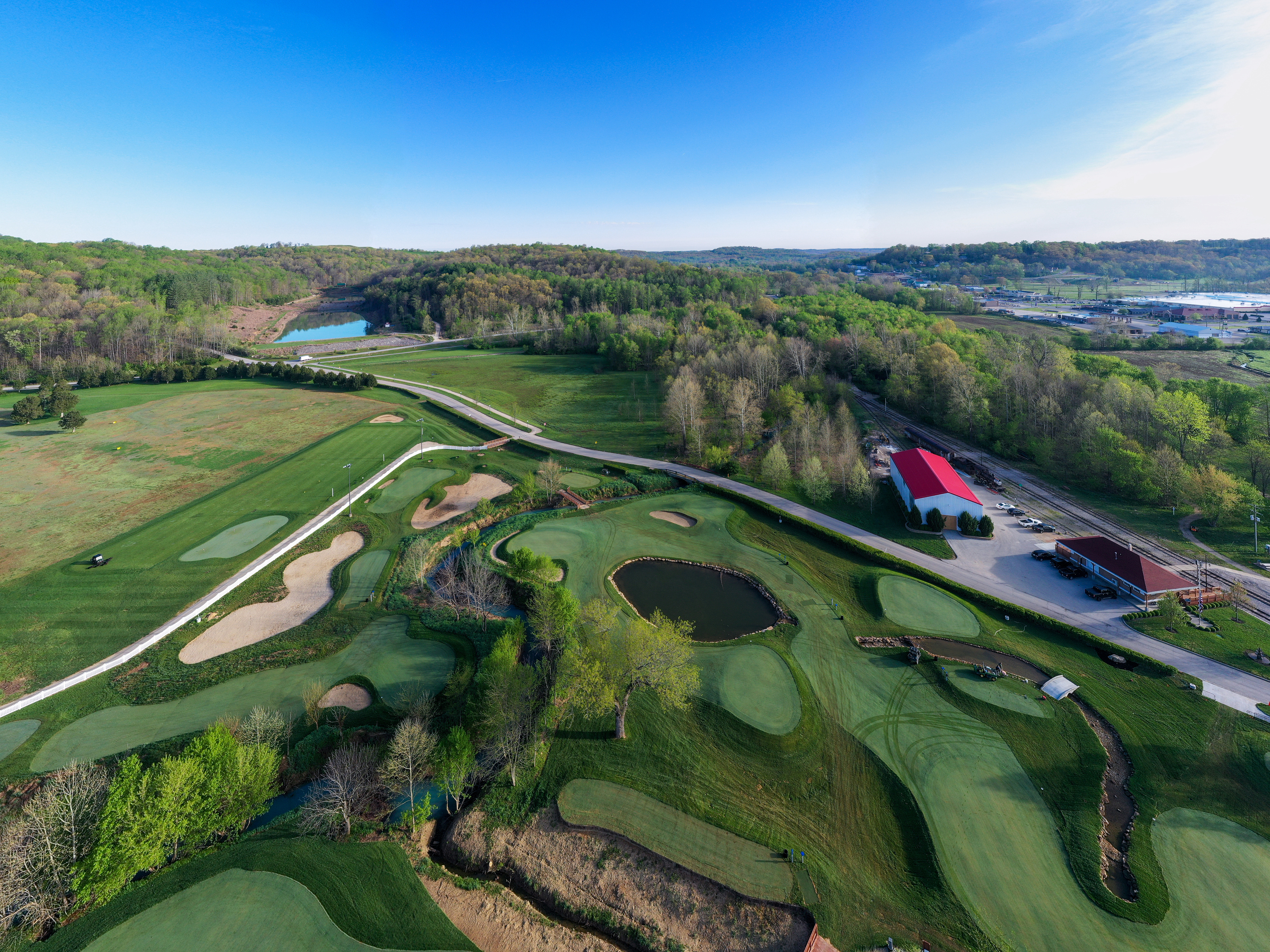 a golf course with a road and a building
