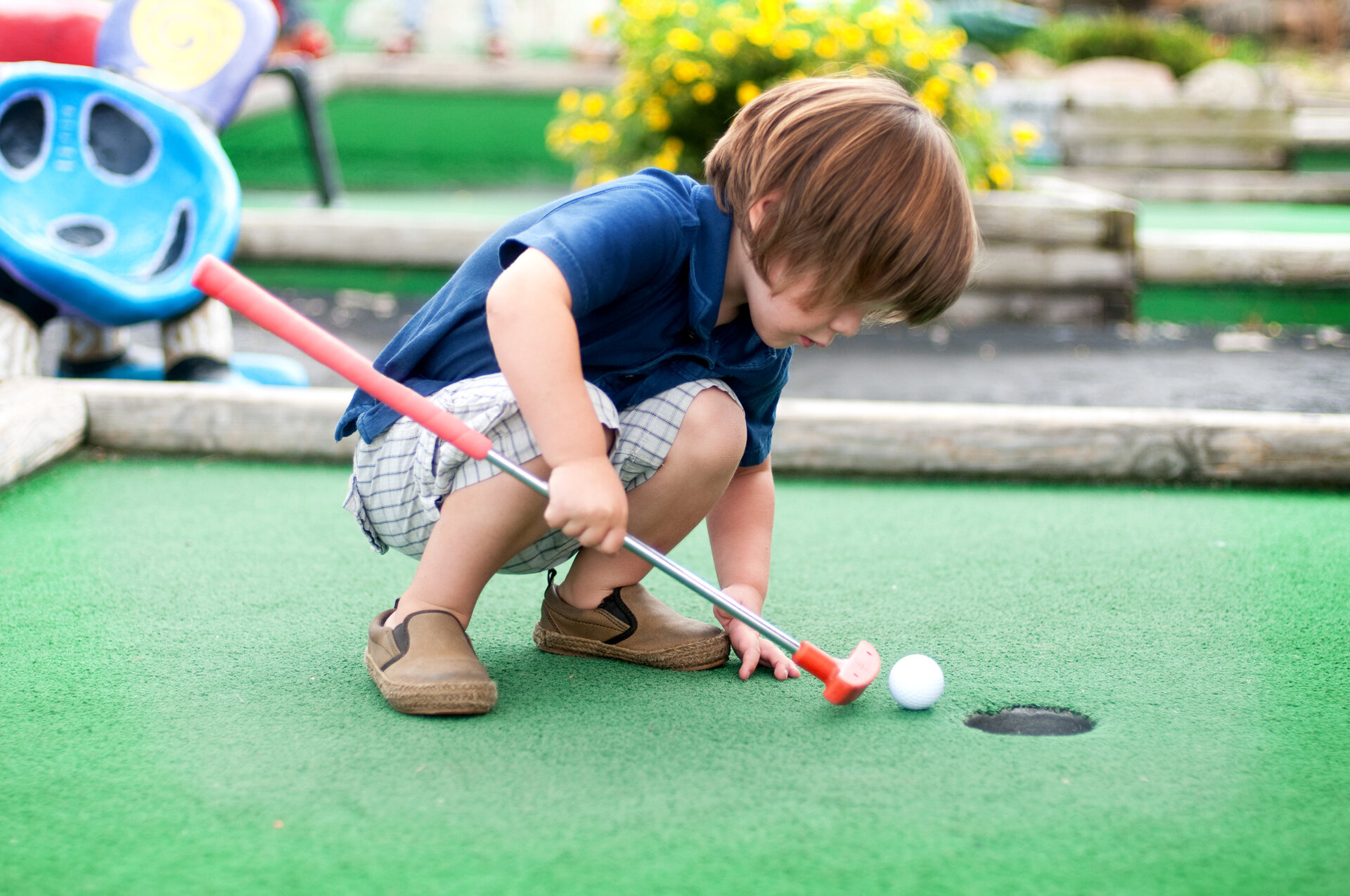 Child playing mini golf