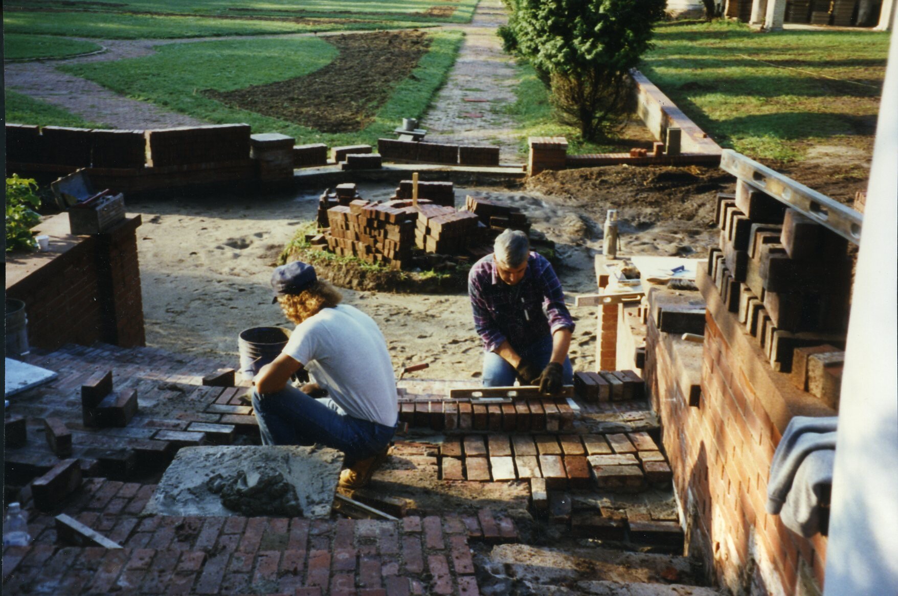 a couple of men building a brick wall