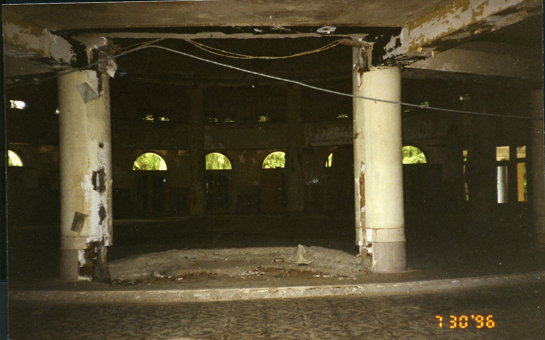 a large room with pillars and a hole in the wall