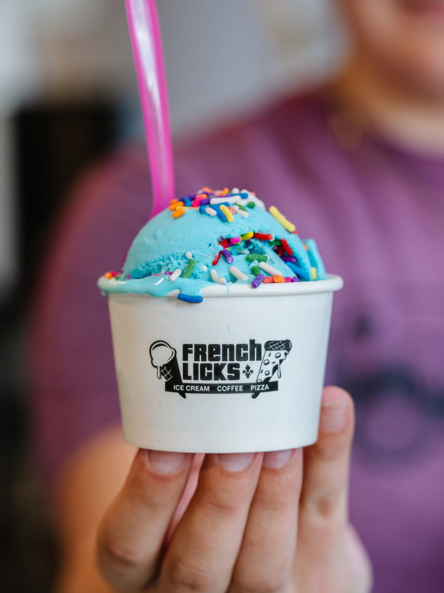 a hand holding a cup of ice cream