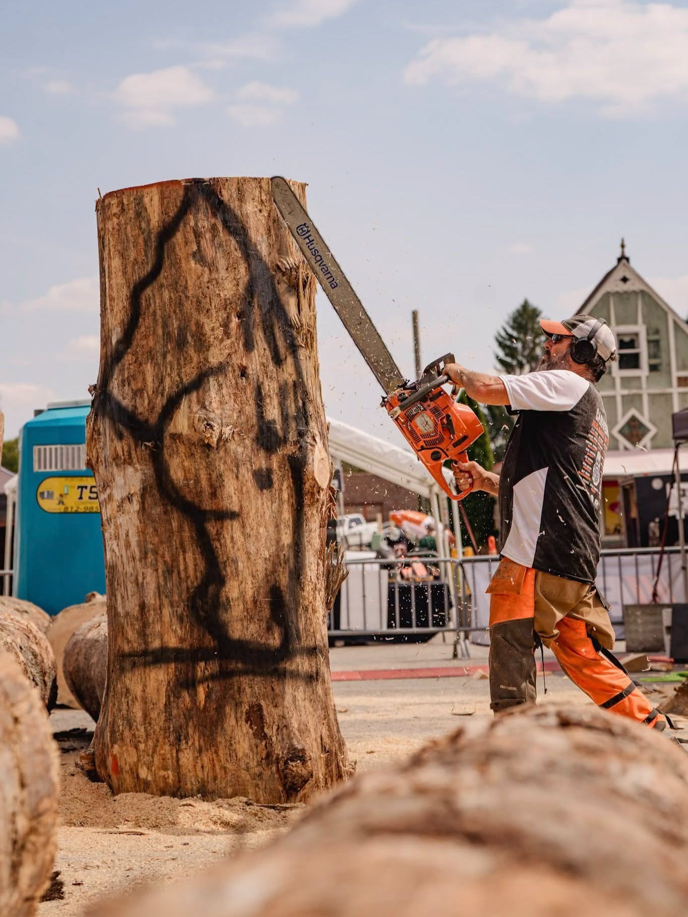 a man using a chainsaw to cut a tree