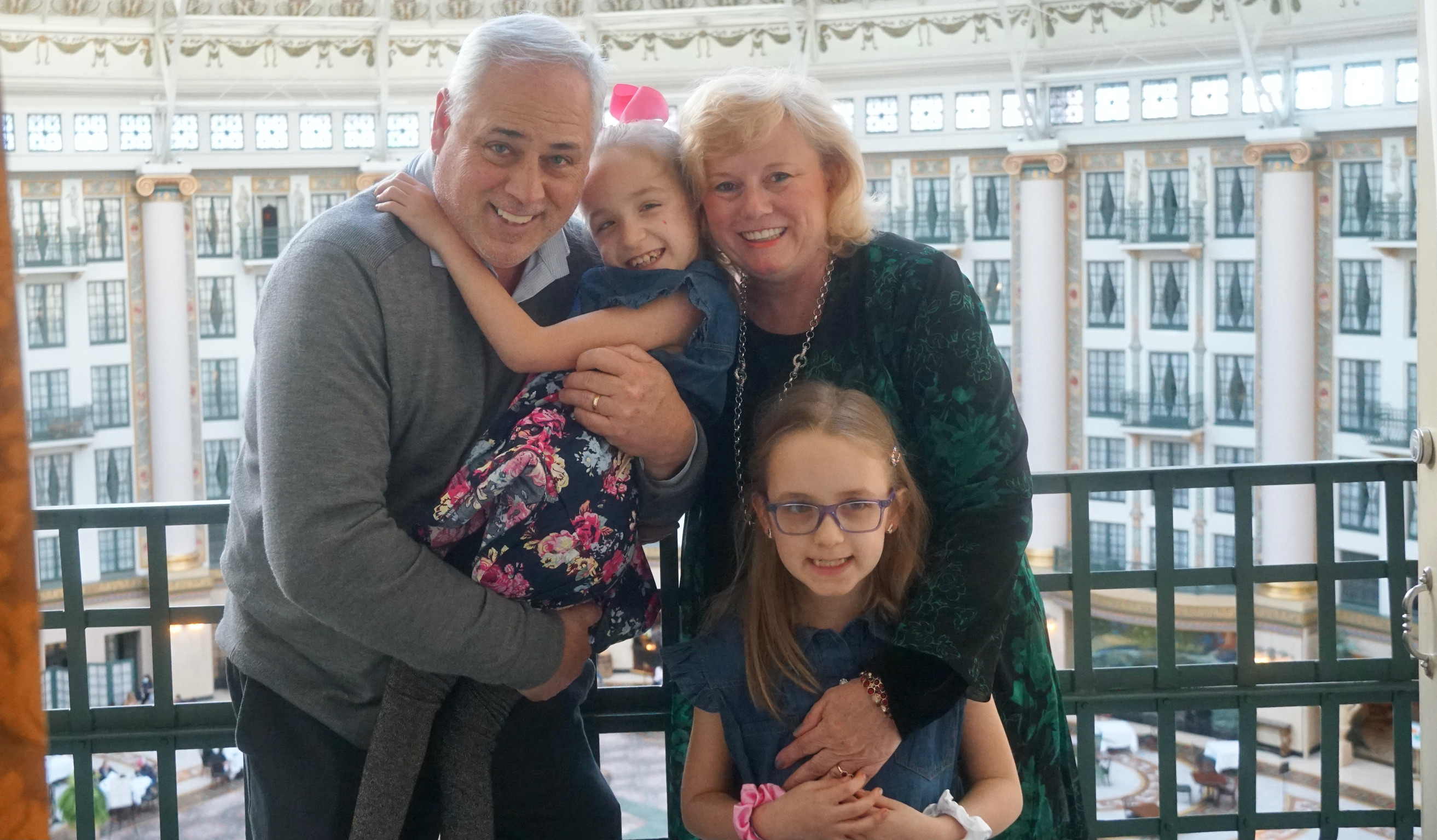 A family posing on a hotel balcony