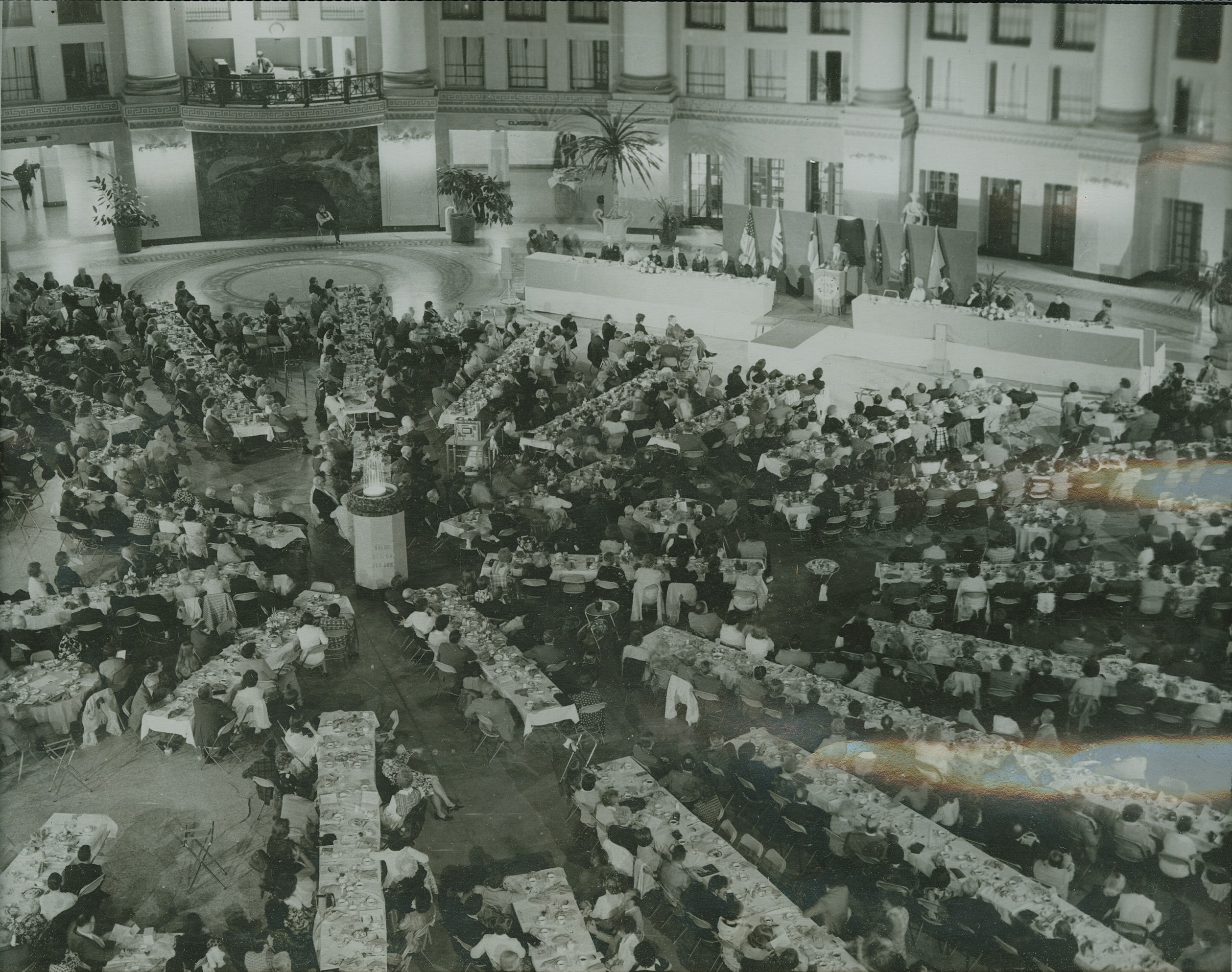 a large group of people sitting at tables in a large room
