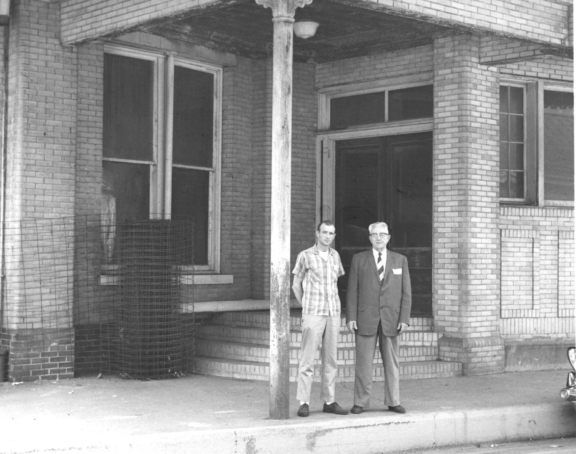 a man and a man standing on a sidewalk