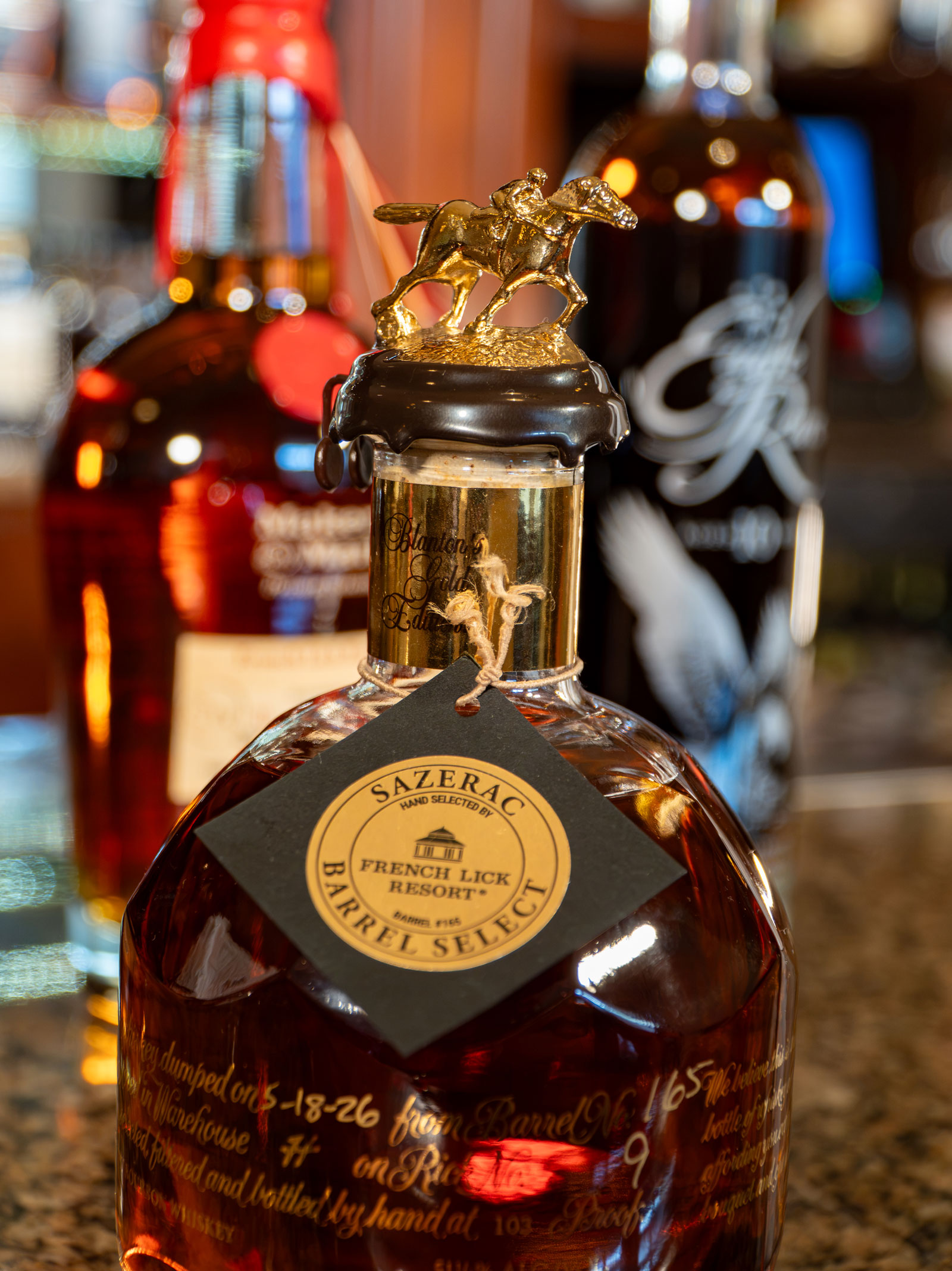 a bottle of liquor with a gold horse statue on top