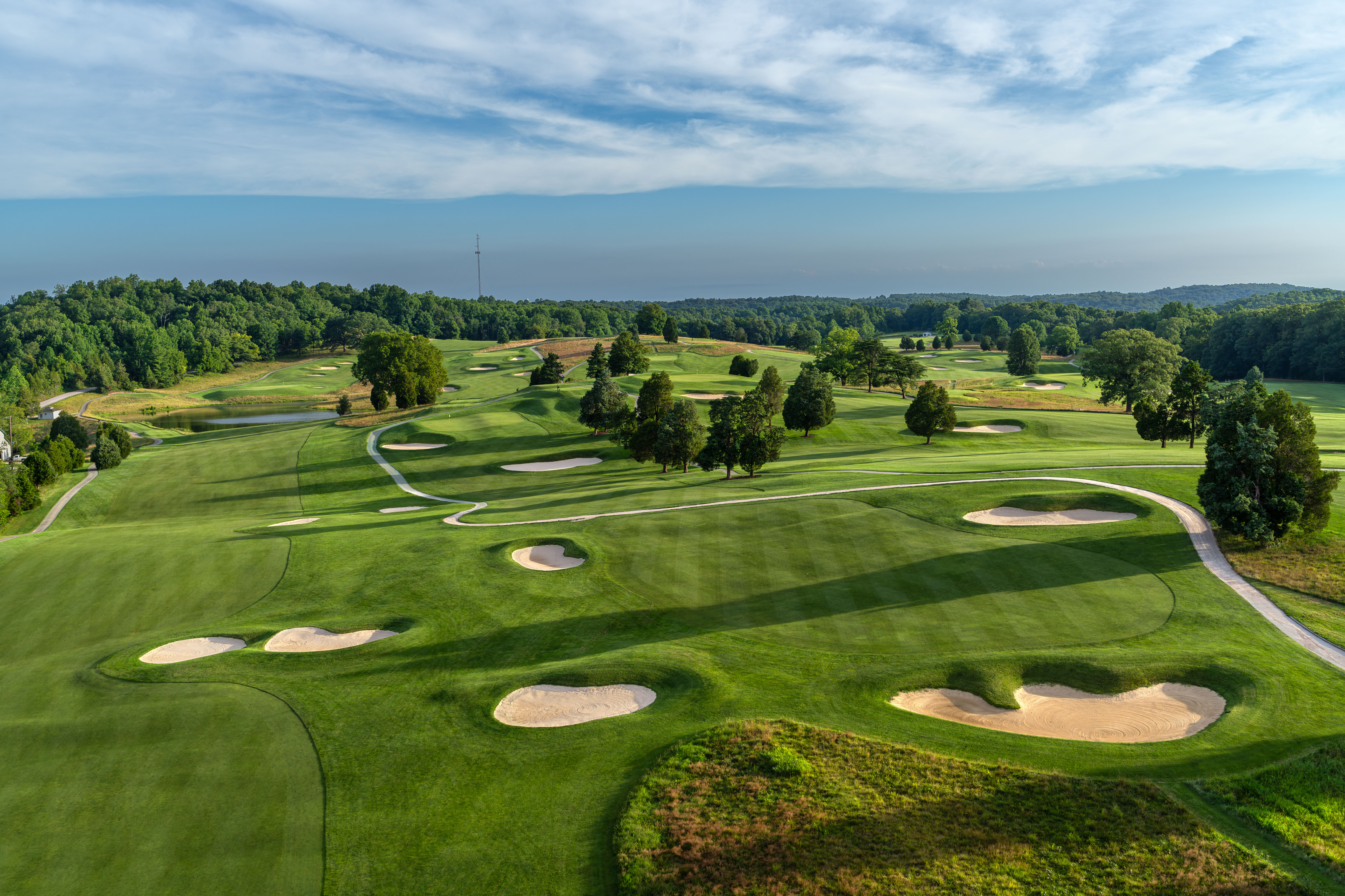 a golf course with sand bunkers and trees