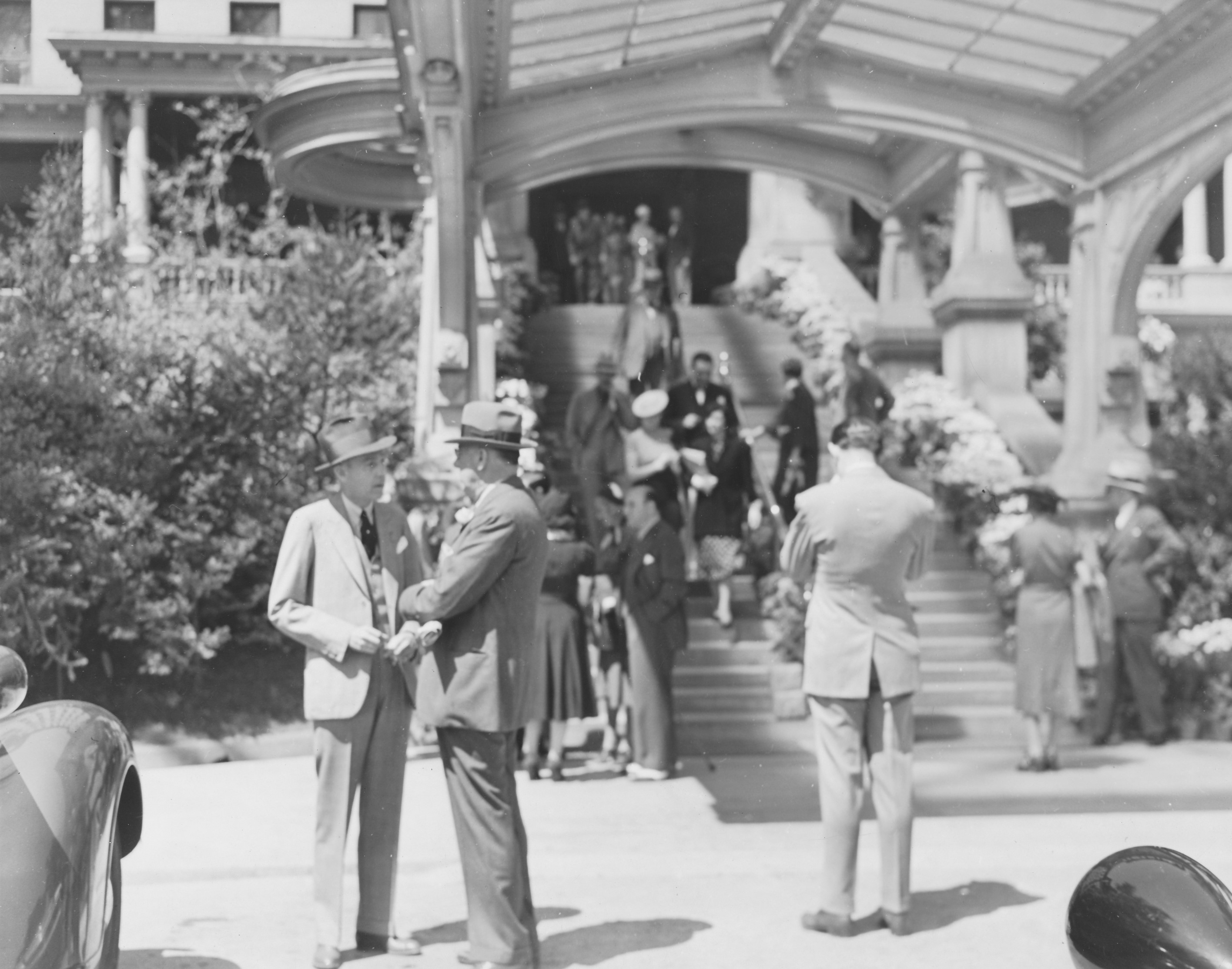 Men talking in front of an old hotel