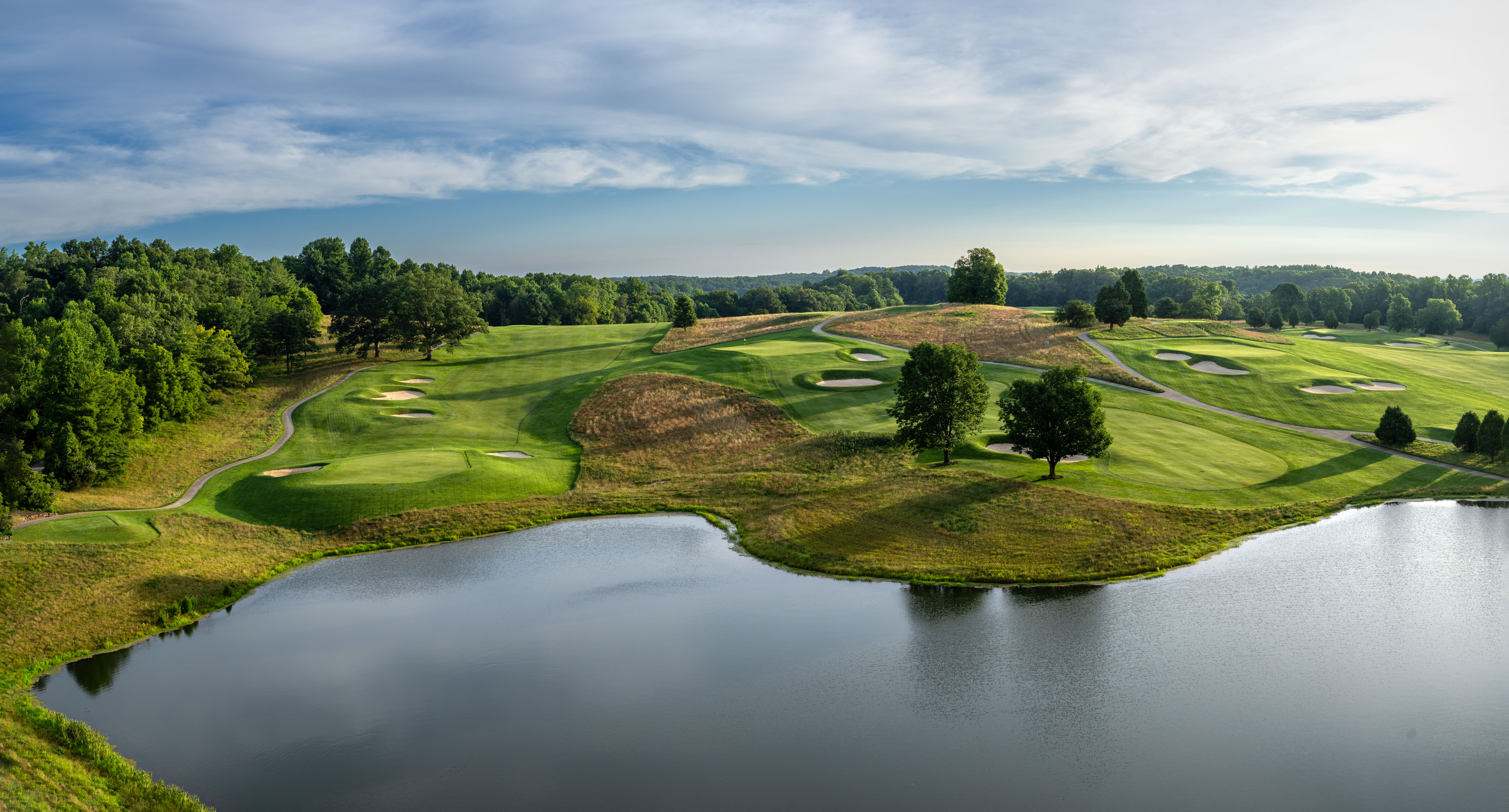 a golf course with a lake and trees