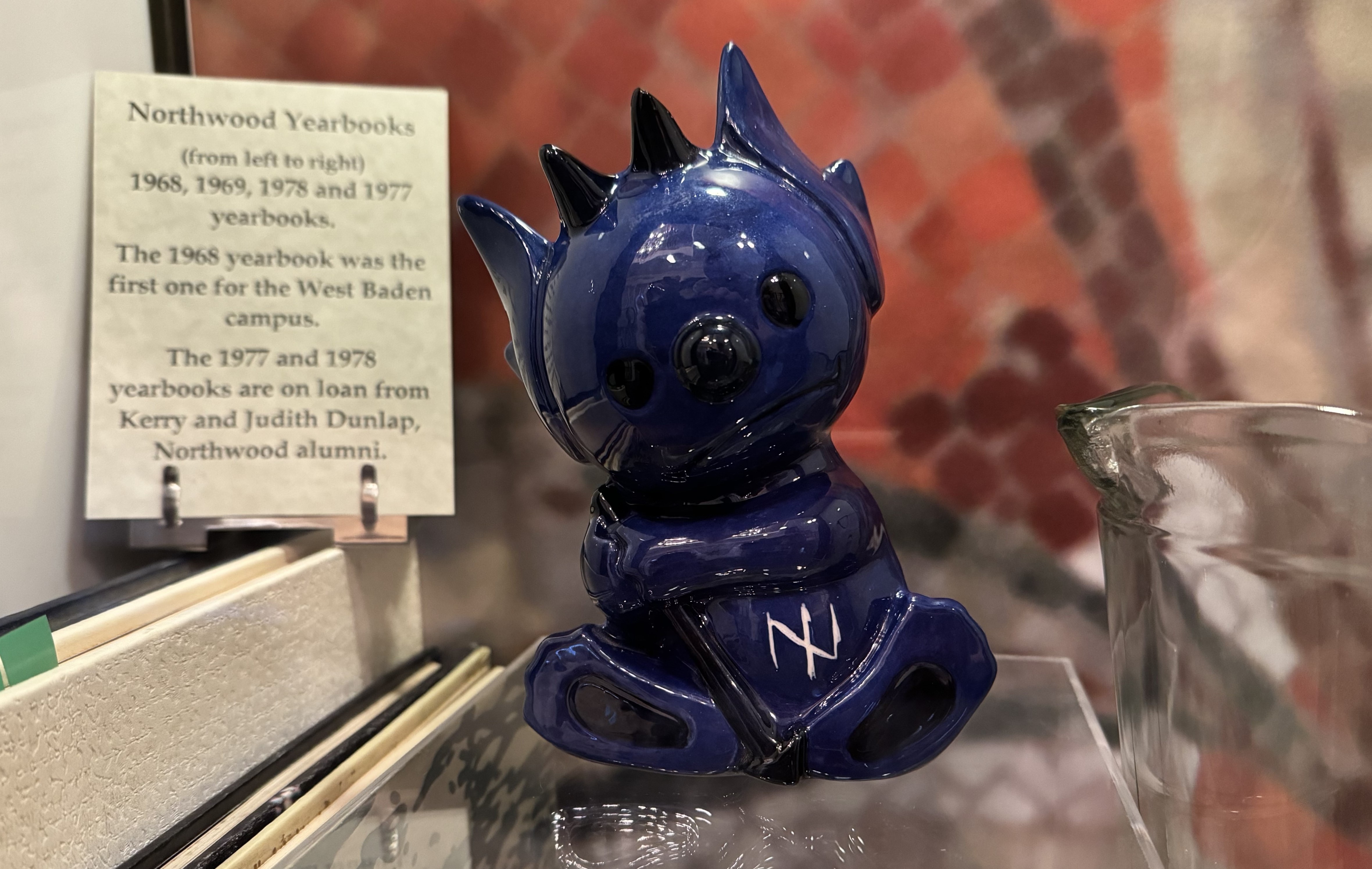 a blue ceramic figurine on a glass shelf