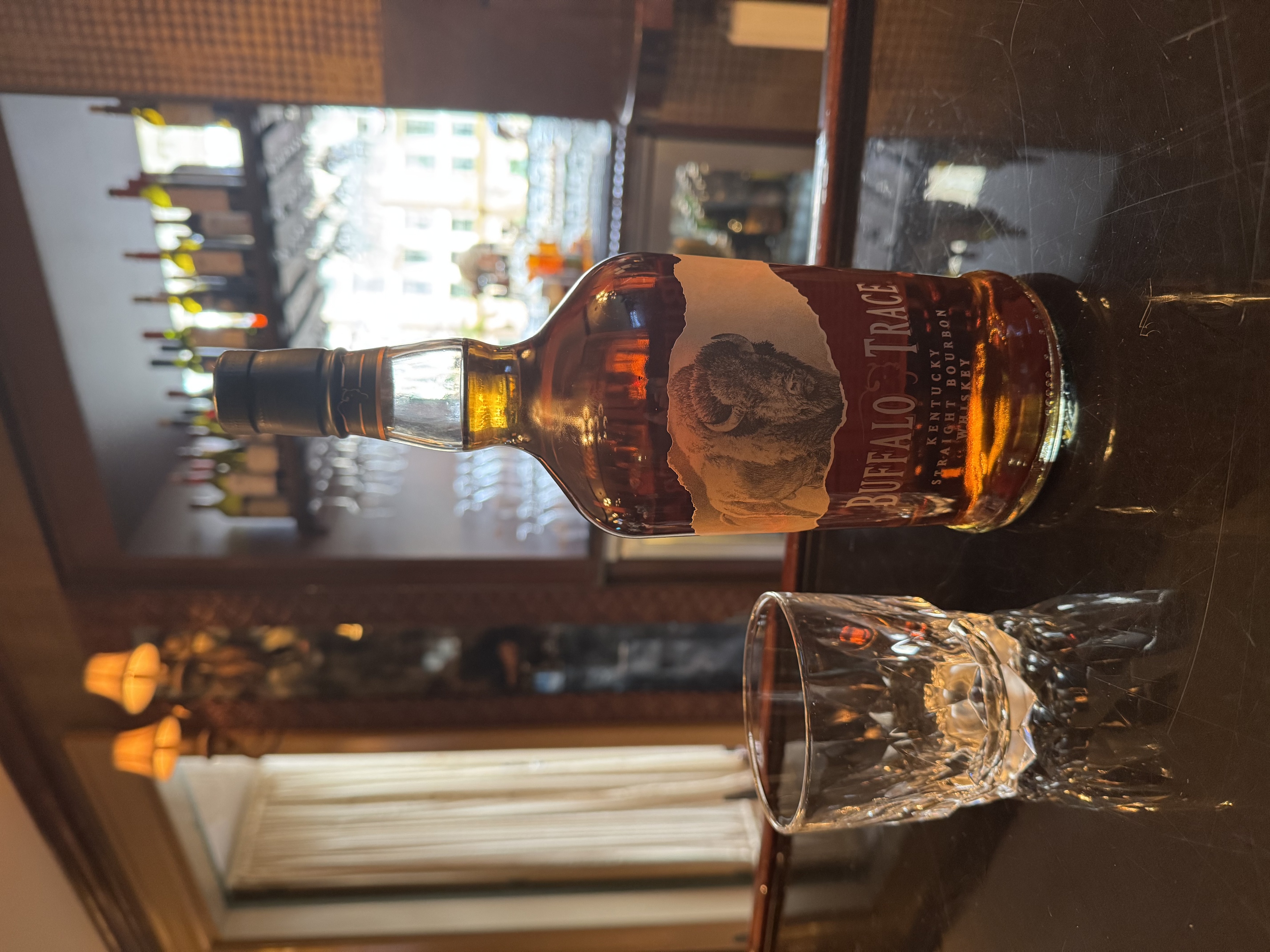 a bottle of alcohol and a glass on a bar