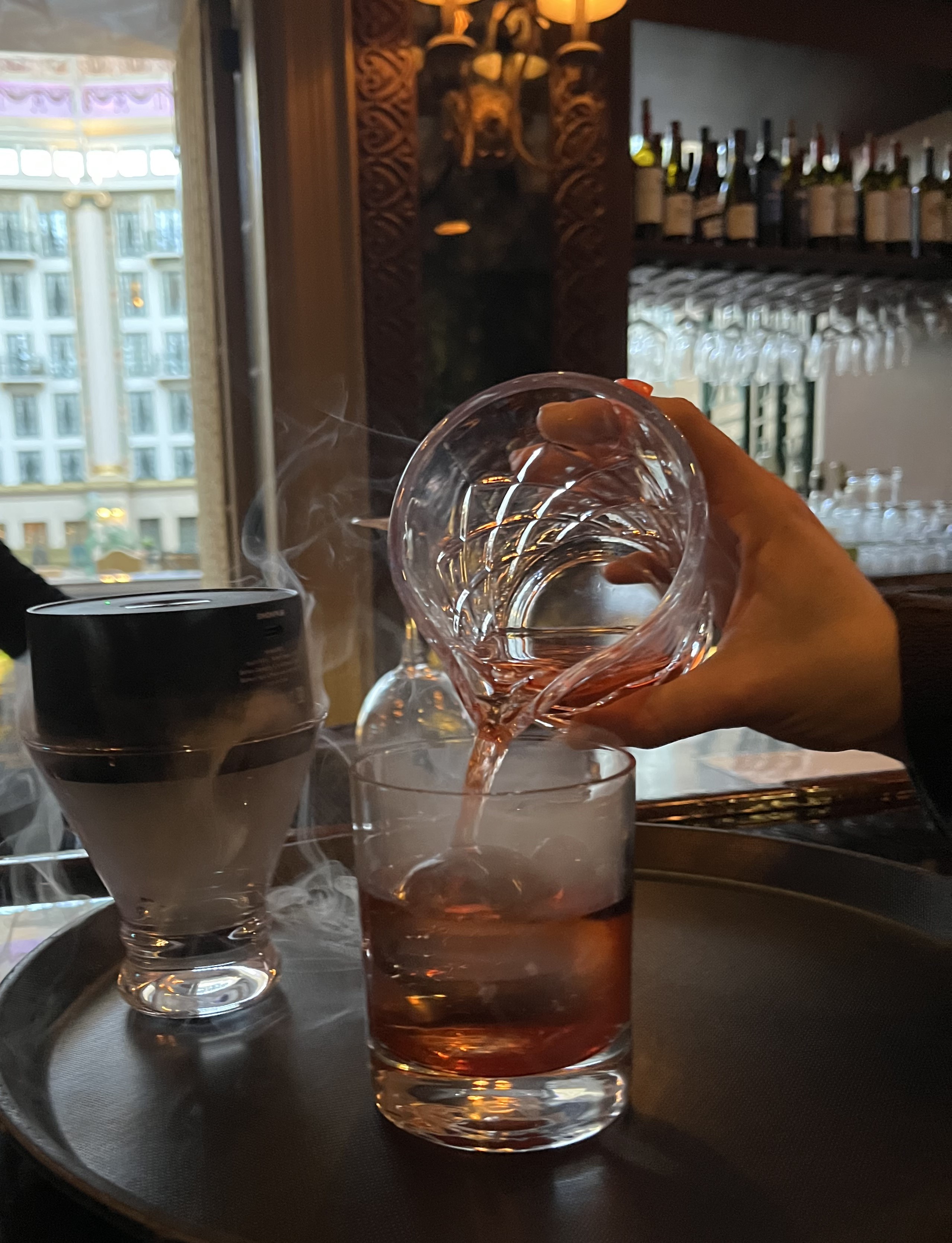 a person pouring a drink into a glass