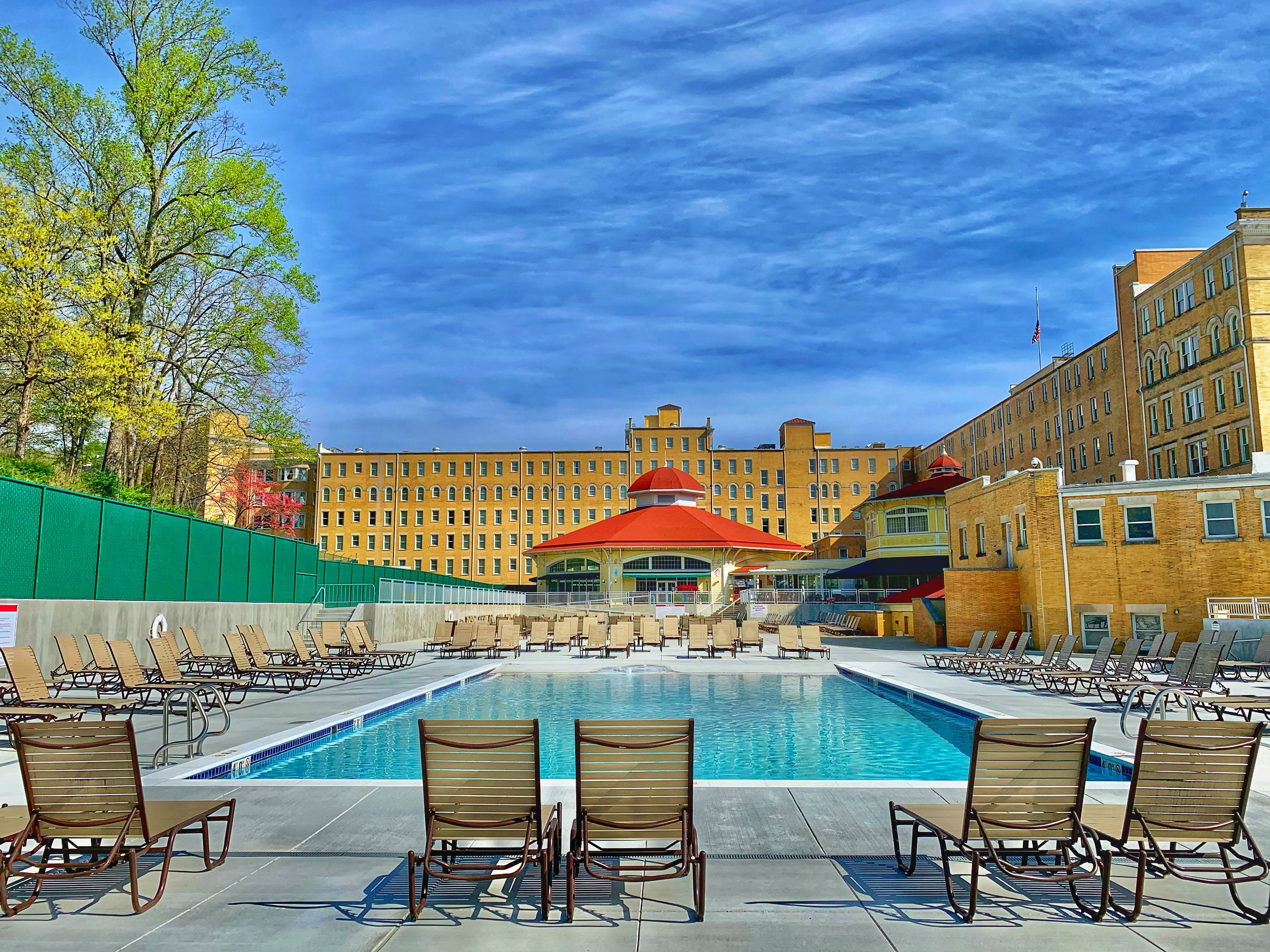 a pool with chairs and a building in the background