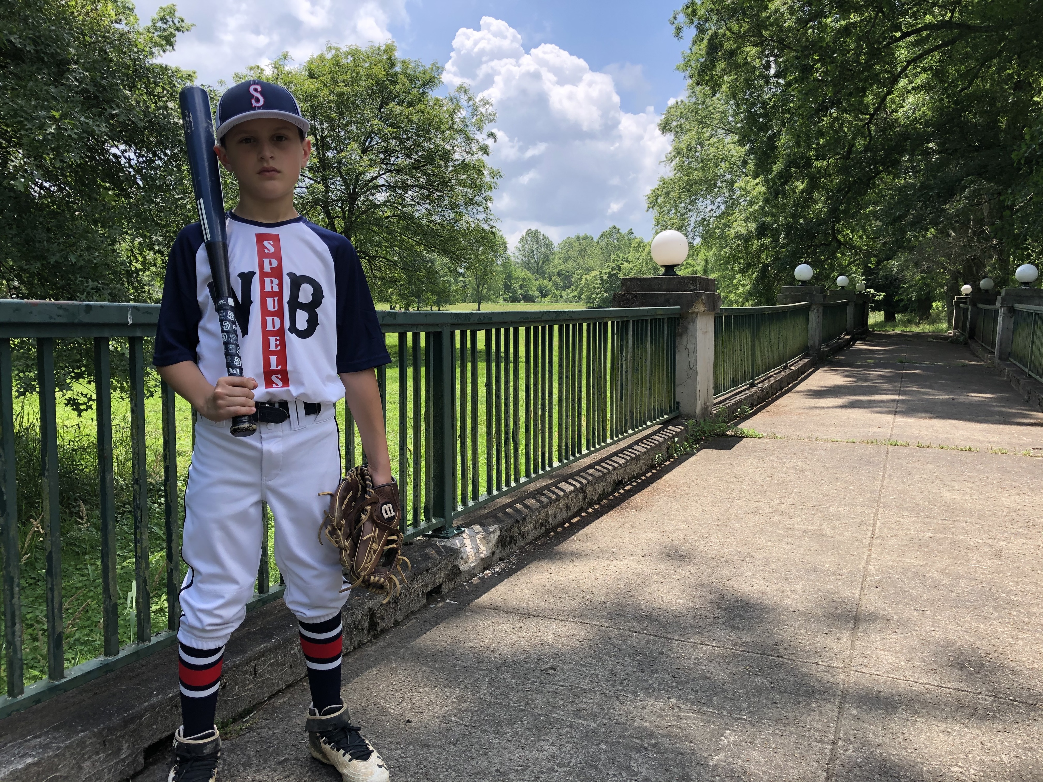 a boy holding a baseball bat and glove