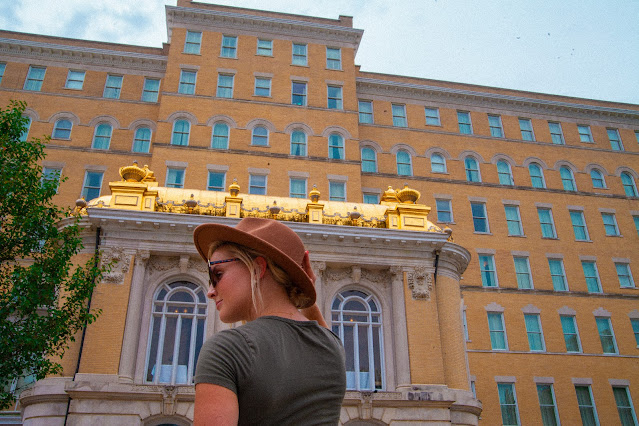 Woman in hat in front of building