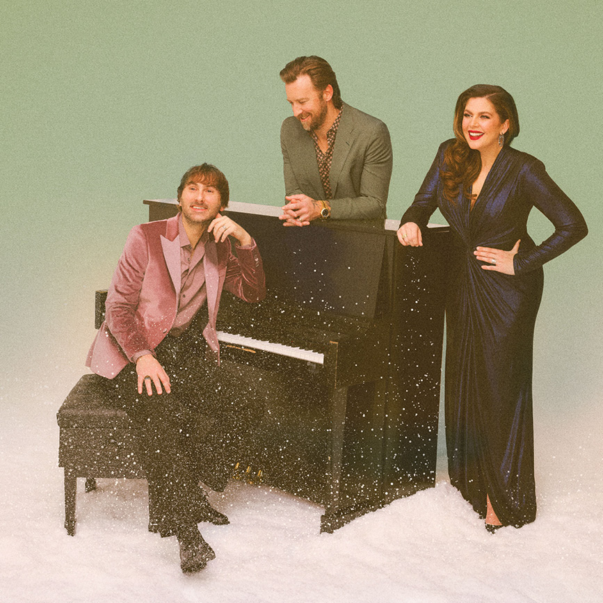 a group of people standing next to a piano