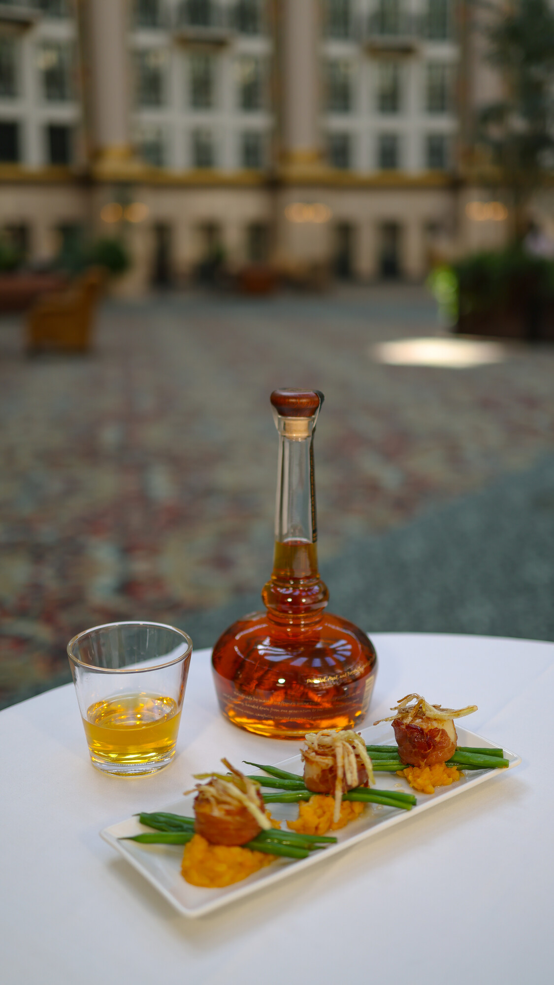 a glass bottle and a plate of food on a table