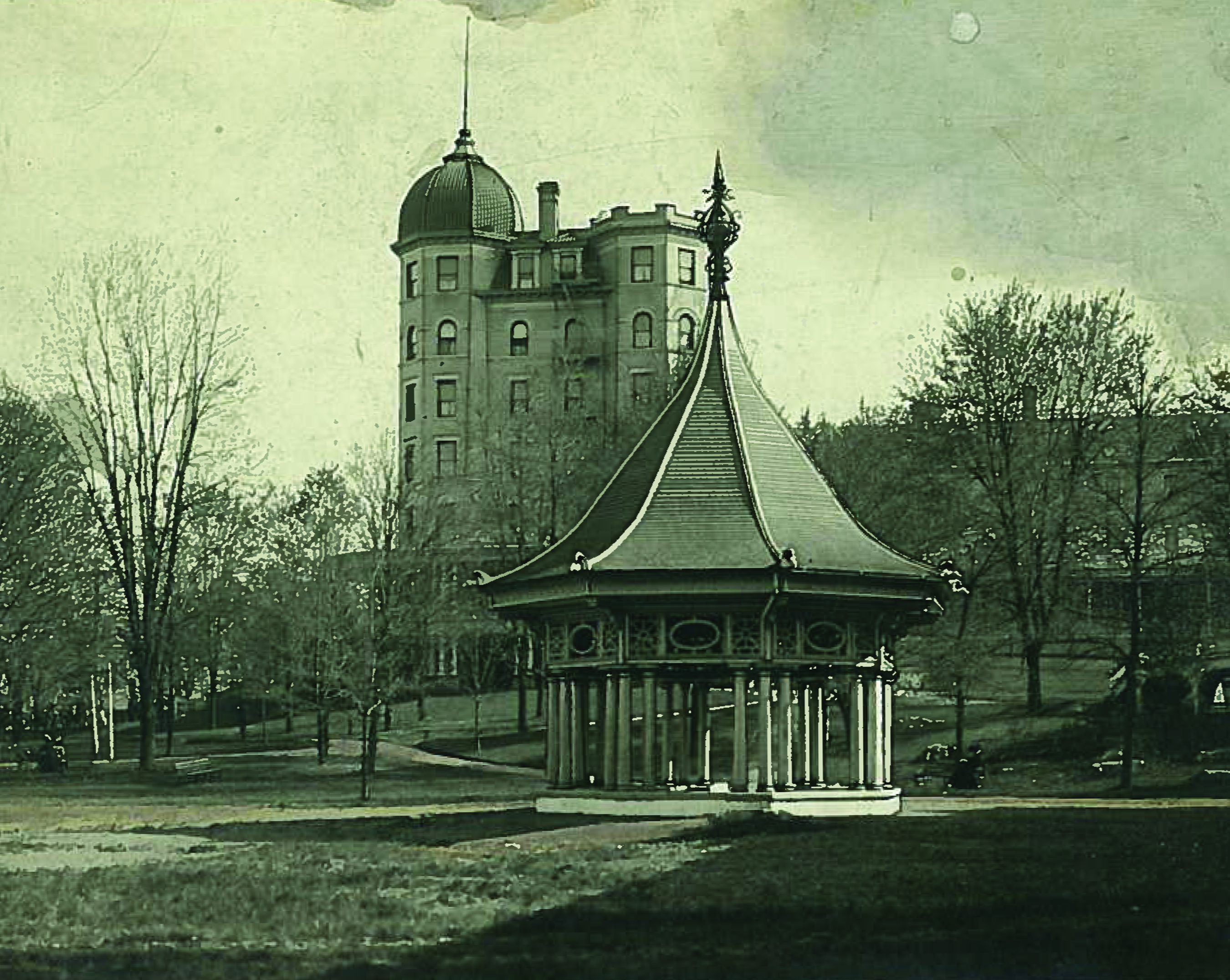 a gazebo in a park with a building in the background