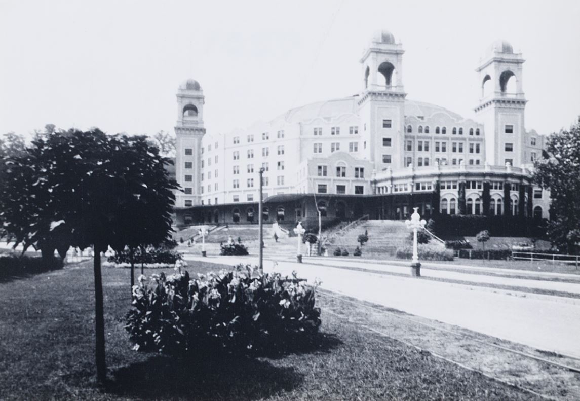 a large building with towers and a lawn