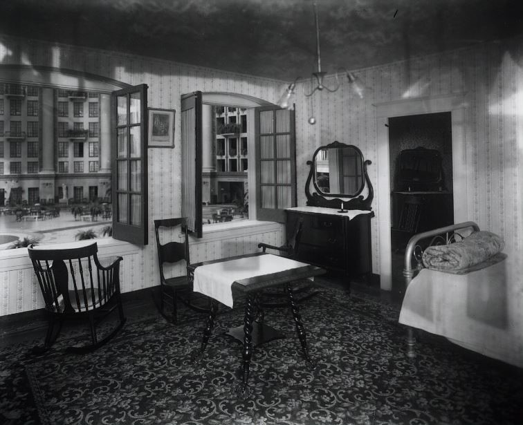 a room with a bed and chairs