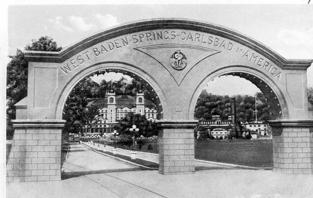 a stone arch with a building in the background