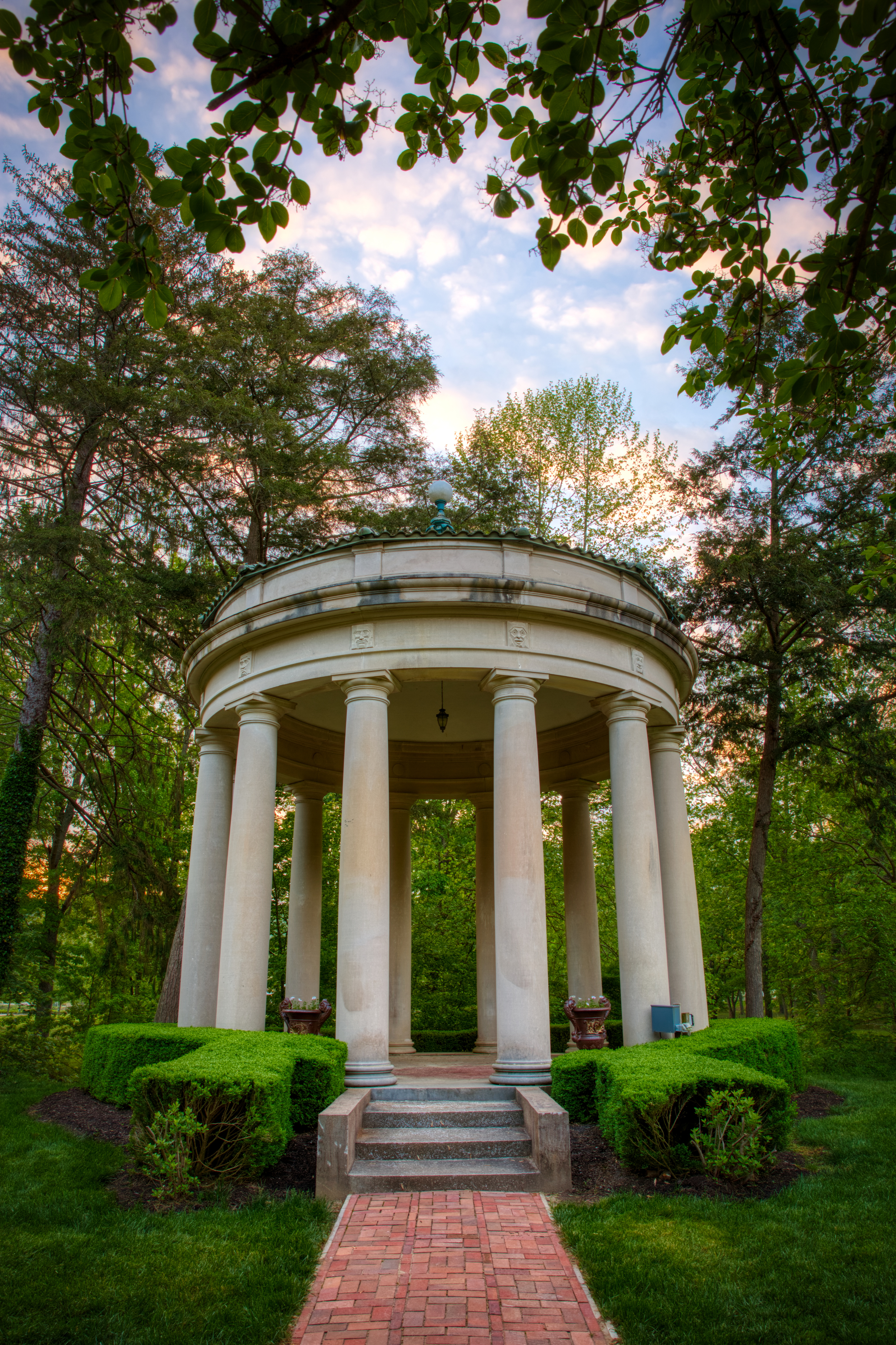 a white gazebo with columns in a park