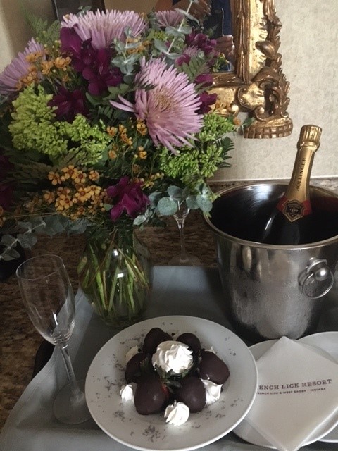 a champagne bottle and a plate of chocolate covered strawberries