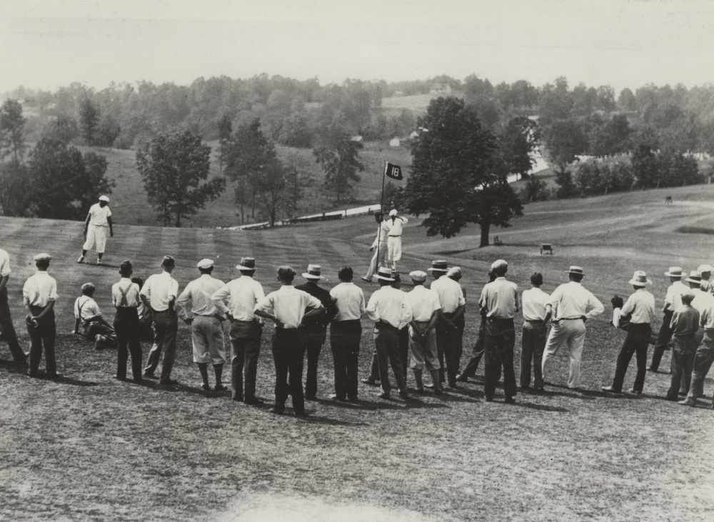 a group of people standing on a golf course