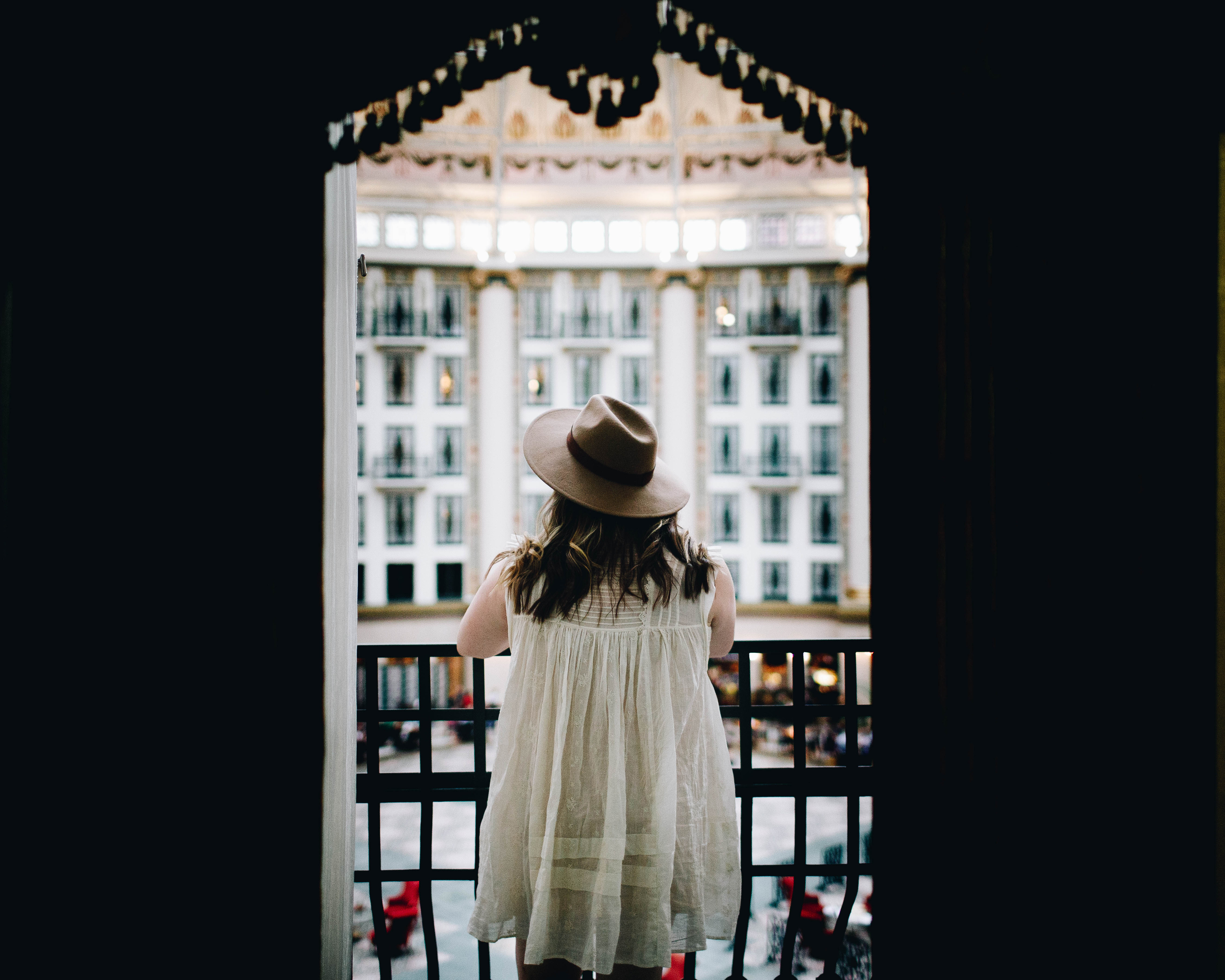 a woman standing on a balcony looking out a window